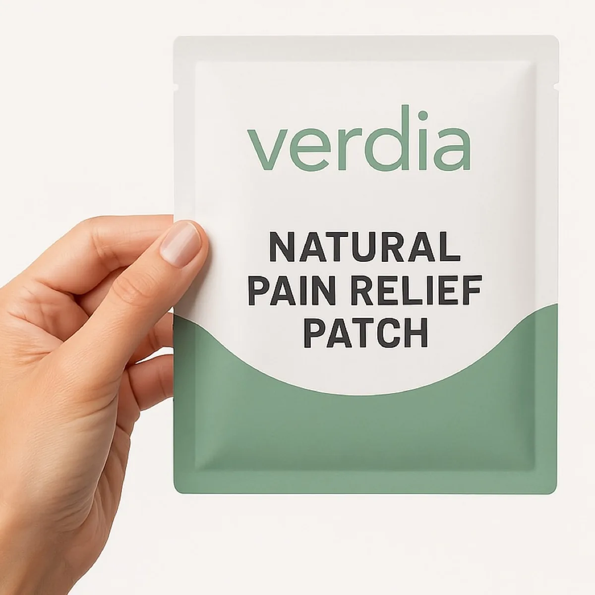 A hand holding a Verdia natural pain relief patch sachet.